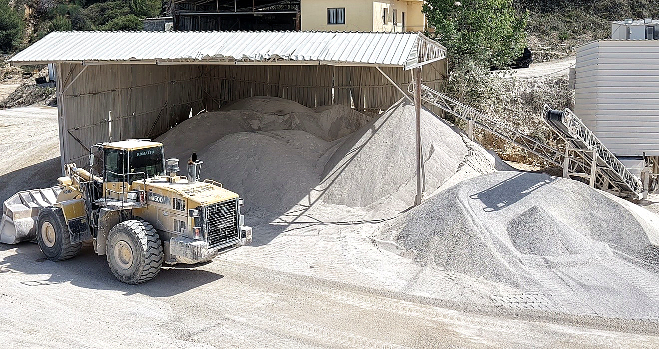 Fadromë duke ngarkuar rërë nga grumbujt e materialit të gatshëm